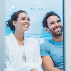 Two people smiling inside a modern integrated dental practice with a cryotherapy-inspired recovery setting.